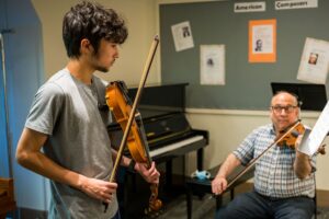 A violin student from Holden takes a summer lesson